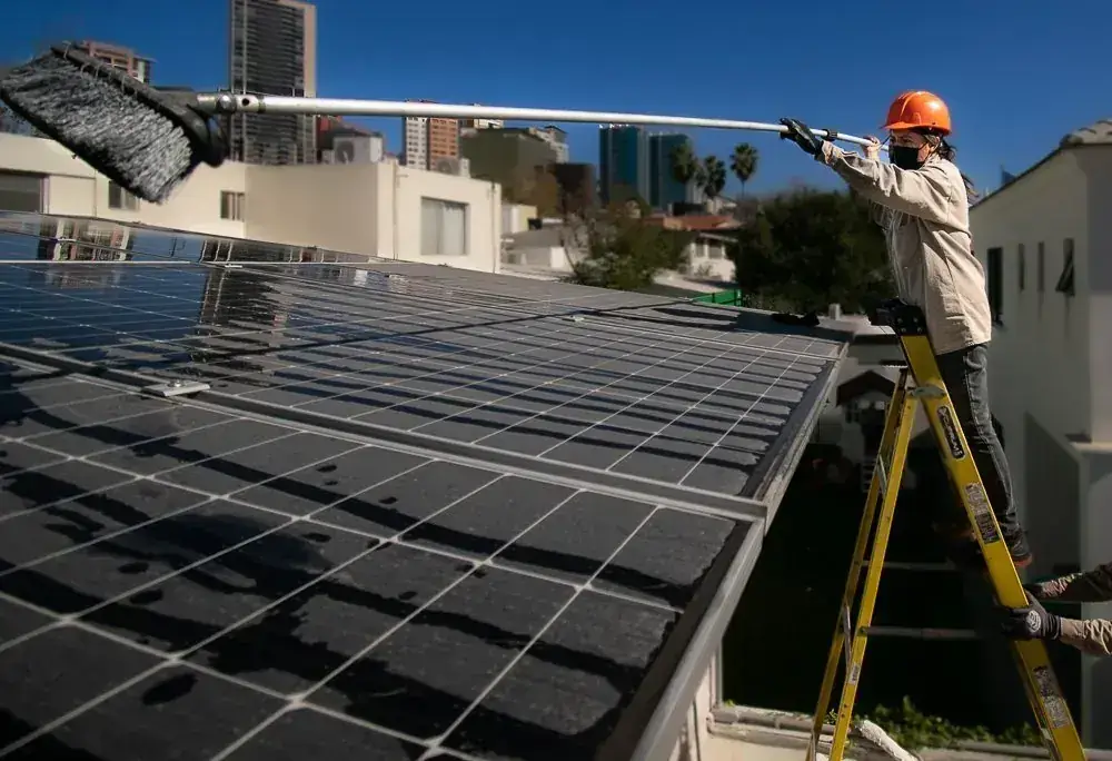 Técnico Energon lavando paneles solares en una azotea