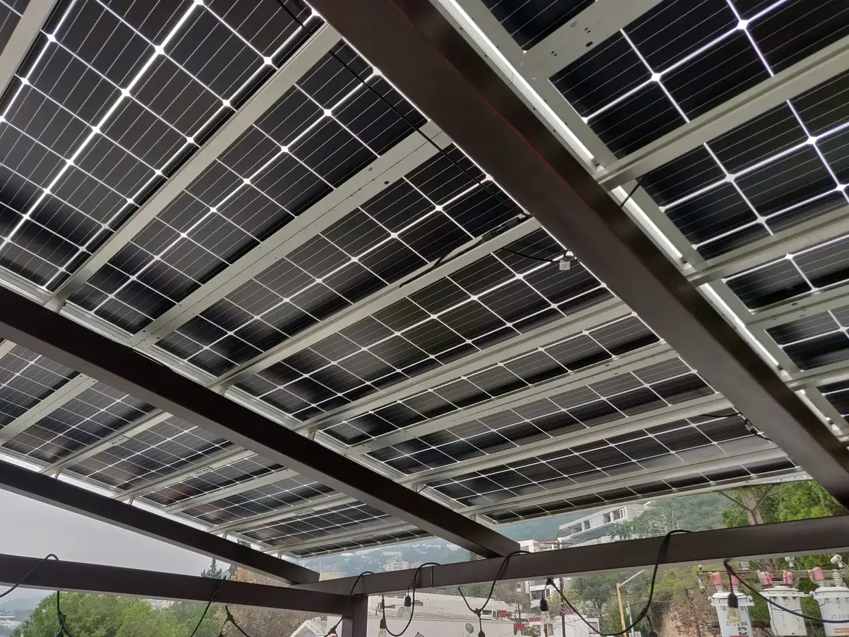 Plafón de una pérgola Energon visto desde abajo: módulos bifaciales con luz filtrada