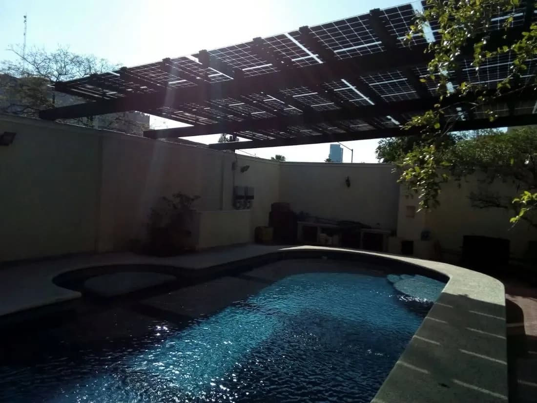 La misma alberca terminada, con pérgola solar bifacial dando sombra