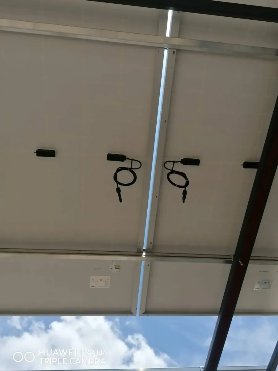 Vista bajo el panel: microinversores y cableado sujetos y canalizados