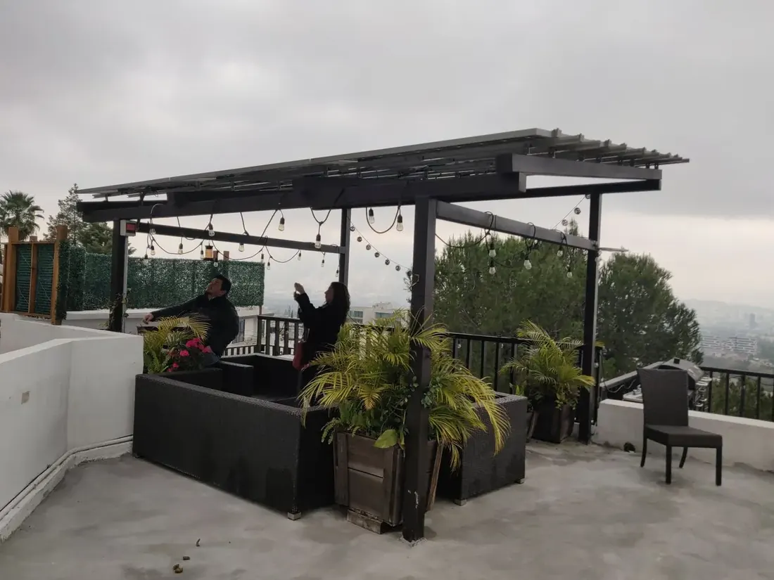 Personas conviviendo bajo el plafón bifacial de la pérgola
